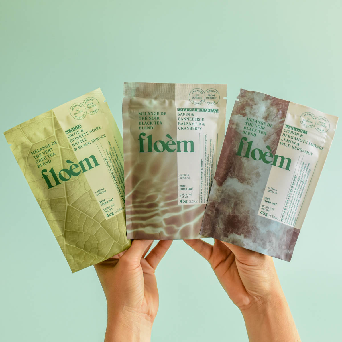 Des mains montrent 3 sacs de thés d'un ensemble assortis.